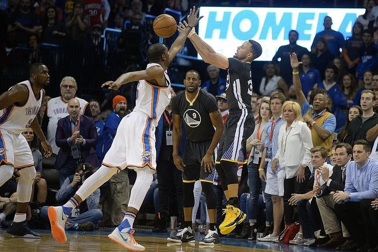Golden State Warriors guard Stephen Curry (right) attempting a three-point shot against Oklahoma City Thunder forward Kevin Durant during the fourth quarter of their NBA game on Saturday. Curry finished with 12 three-pointers, tying the NBA single-ga