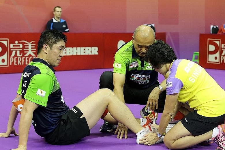 Gao Ning receiving treatment after spraining his ankle yesterday. The Singaporean returned to the table after 10 minutes but lost to Poland's world No. 82 Jakub Dyjas in the first singles. He later bounced back to beat Wang Zengyi in the fourth singl