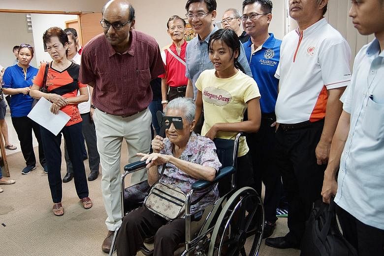 Deputy Prime Minister Tharman Shanmugaratnam (in purple) visiting an eye screening station at yesterday's health carnival in Jurong. He noted that elderly residents were especially appreciative of such neighbourhood fairs as they bring health service