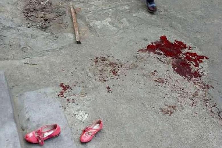 Bloodstains outside an elementary school in Haikou yesterday, where a man attacked several pupils with a knife before killing himself.