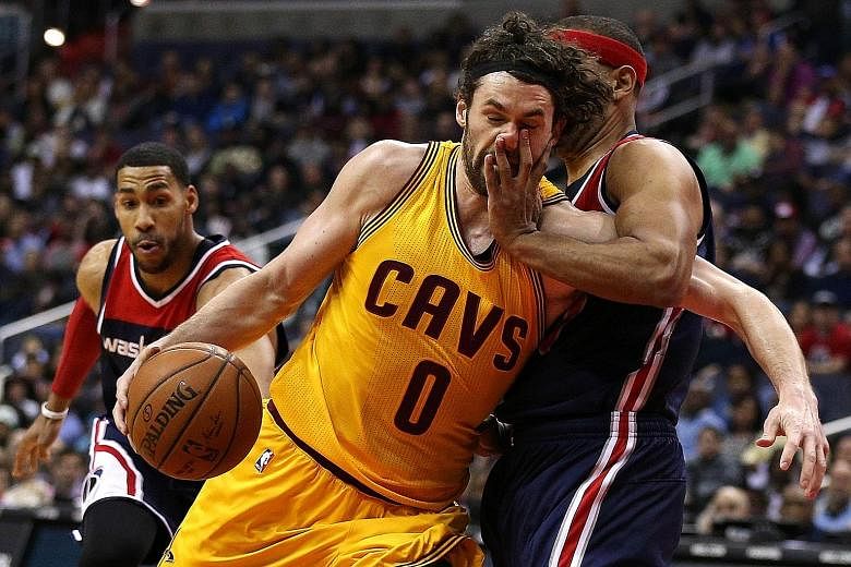 Cleveland forward Kevin Love (No. 0) is fouled by the Washington Wizards' Jared Dudley as he drives to the basket. The Wizards won 113-99 and the Cavs fell to their second straight loss.