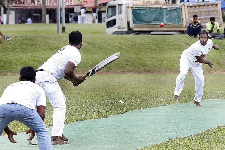 On this field in Race Course Road, foreign workers from India and Bangladesh answer the call of cricket on Sunday and are, momentarily, at home again.