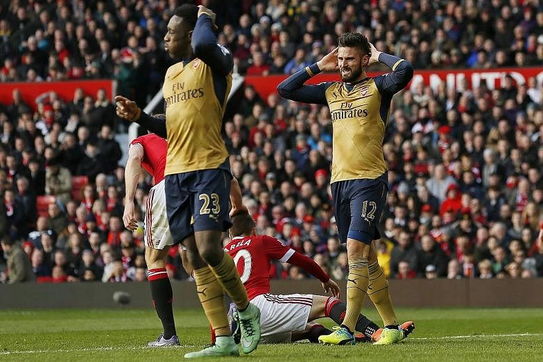 Arsenal players Danny Welbeck (left) and Olivier Giroud looking dejected during their 3-2 defeat by Manchester United at Old Trafford on Sunday. The Gunners are five points behind Premier League leaders Leicester City and three behind Tottenham Hotsp