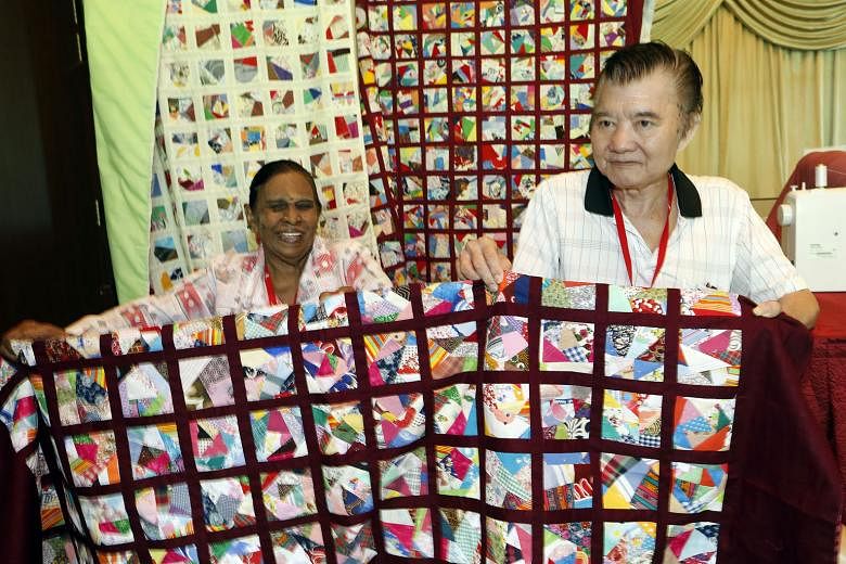 Ms Lachimee (left), a participant of the Weaving Love, Mending Hearts programme, presenting a quilt to Mr Ong Yu Seng. About 300 residents made 40 quilts for needy seniors at Fei Yue's eldercare centres.
