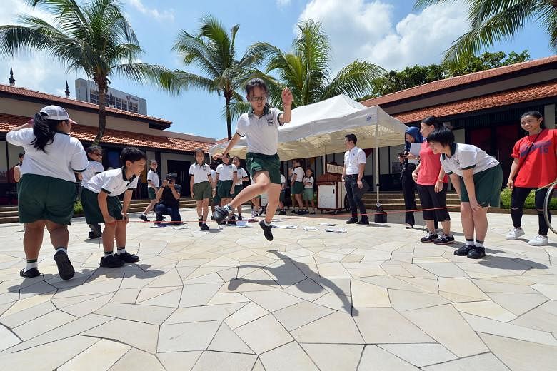 Primary 4 and 5 pupils from Pei Tong Primary School taking part in a Heritage Explorers programme at the Malay Heritage Centre yesterday, where they earned badges by learning about traditional games. 