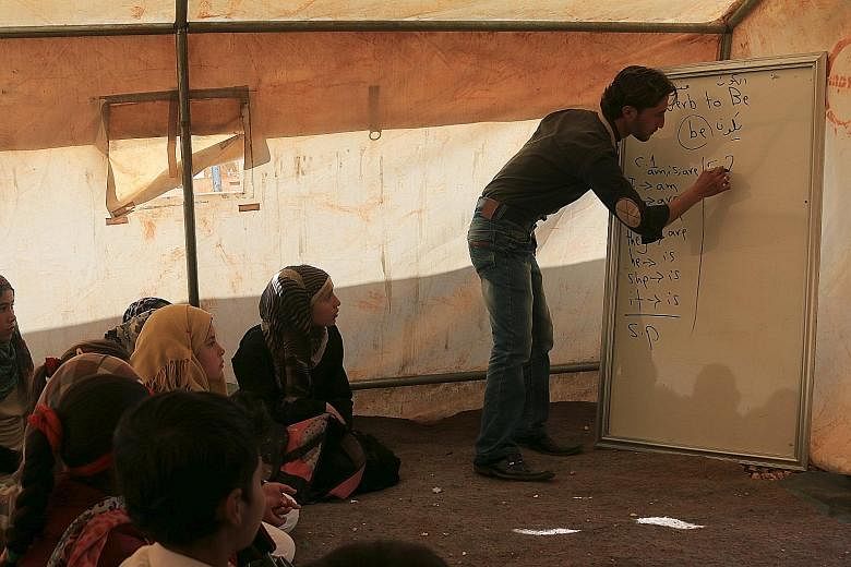 Internally displaced Syrian children attending lessons in a makeshift classroom at a camp in Idlib province.