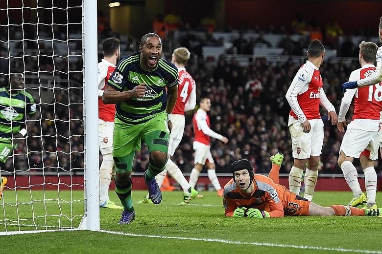 Swansea City defender Ashley Williams in jubilant mood after scoring the second goal against Arsenal as goalkeeper Petr Cech looks on. The 2-1 win puts Swansea six points clear of relegation and the Gunners have now lost three straight games in all c