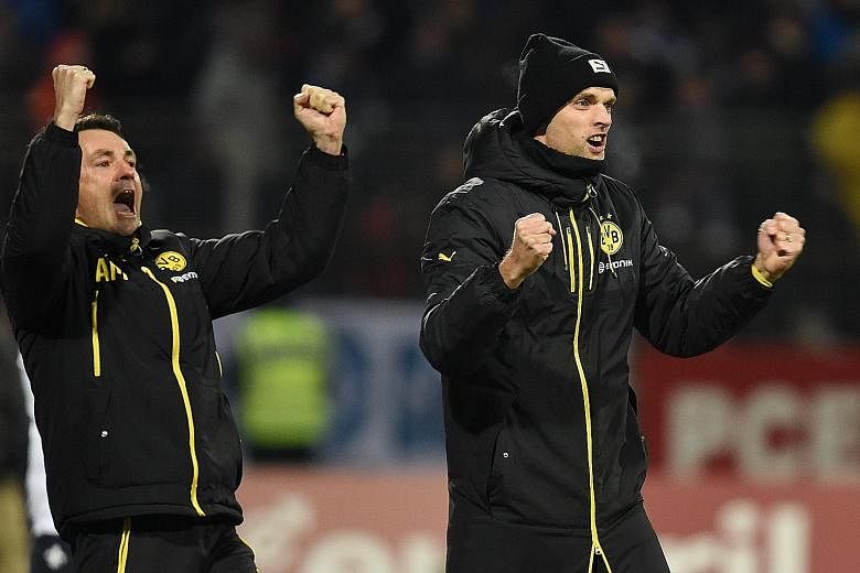 Borussia Dortmund manager Thomas Tuchel (right) celebrating with assistant Arno Michels during their 2-0 German Bundesliga win over Darmstadt on Wednesday. The result puts them five points behind league leaders Bayern Munich ahead of tonight's top-of