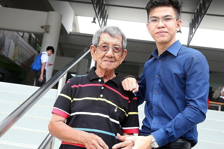 Richmond, 18, with his grandfather Tan Khoon Seng, 78, who holds a cleaning job and is the sole breadwinner of the family.