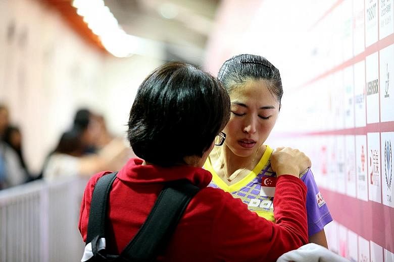 A shattered Yu Mengyu, who blamed herself for letting the team down, being consoled by an official (above) after her rubber-game loss to North Korea's Kim Song I (below) in the quarter-finals yesterday afternoon.