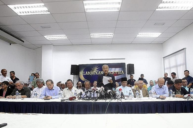 Former Malaysian prime minister Mahathir Mohamad (standing) speaking to the press yesterday after a 58-member group led by him signed what they called a Citizens' Declaration to call for PM Najib's removal from office. The declaration also demanded, 
