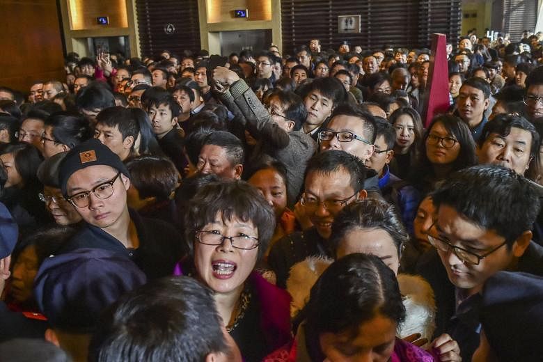 A crowd waiting as a residential compound opened for sale in Hangzhou last month. The city is planning to give migrant families local household permits, or hukou, to encourage them to buy homes in four counties.