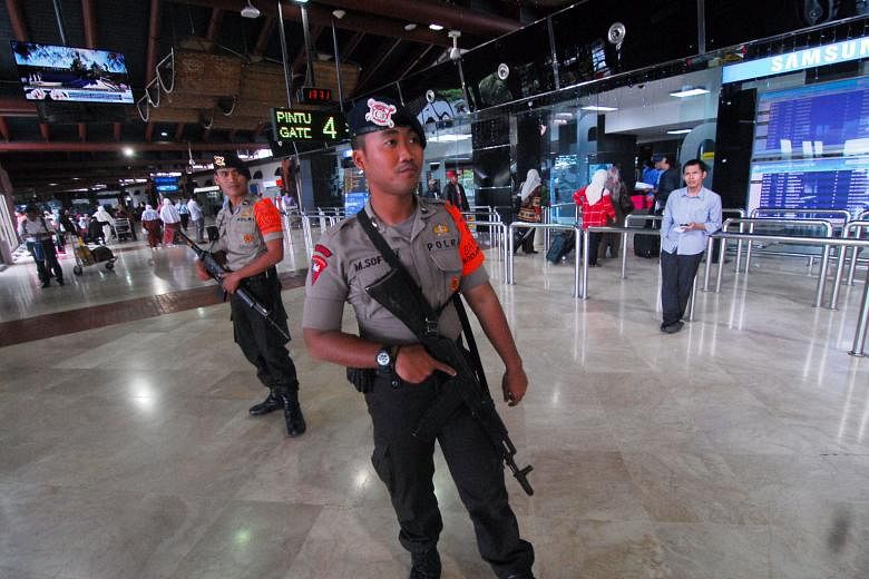 Police officers on guard inside a terminal of the Soekarno-Hatta international airport in Jakarta, which was one of the other planned terror targets, apart from police posts and stations, an international school, as well as Bali and other places frequente