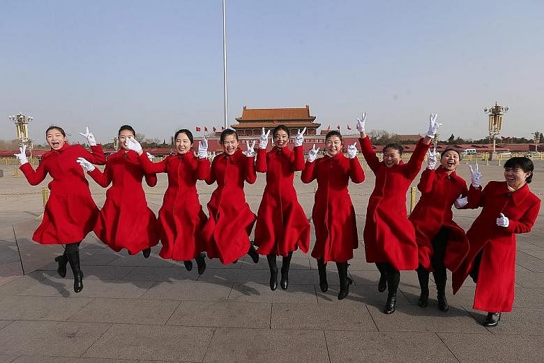 Hostesses all smiles as they execute a jump for the album at the opening of the fourth session of the 12th National People's Congress at Tiananmen Square in Beijing yesterday, attended by about 2,900 delegates.
