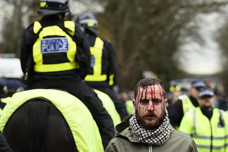 A supporter with blood streaming down his face after Tottenham Hotspur and Arsenal fans clashed outside White Hart Lane before their North London football derby yesterday. Police on horseback were forced to intervene as events threatened to spiral ou