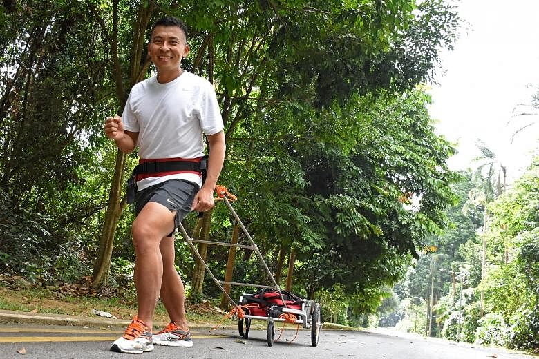 Mr Toh pulls a cart laden with up to 30kg of weight up Bukit Batok Hill as he trains. He remembers going to school without food on some days, and is taking part in the Arctic race to help The Straits Times School Pocket Money Fund.
