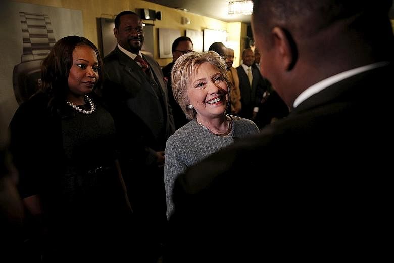 Senator Bernie Sanders (left) arriving for a rally in Warren, Michigan, and Mrs Hillary Clinton (right) meeting African-American ministers in Detroit, Michigan, last Saturday. The next big contest for the Democratic candidates will be tomorrow's prim