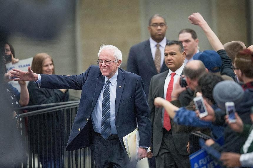 Senator Bernie Sanders (left) arriving for a rally in Warren, Michigan, and Mrs Hillary Clinton (right) meeting African-American ministers in Detroit, Michigan, last Saturday. The next big contest for the Democratic candidates will be tomorrow's prim