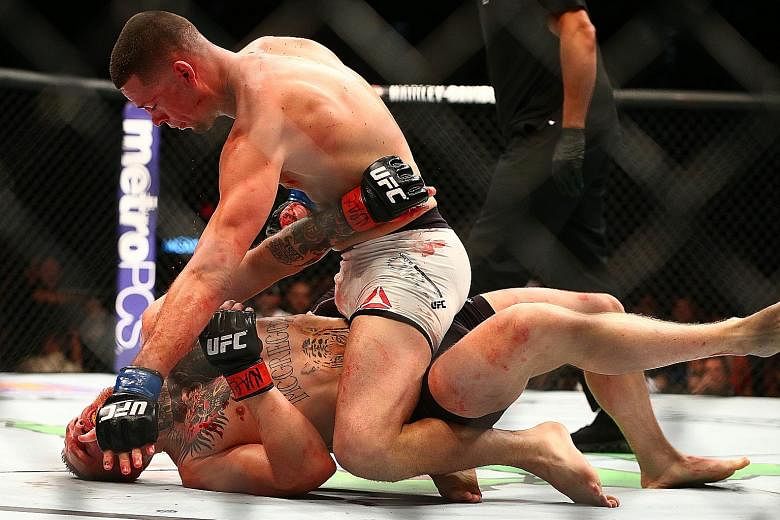American Nate Diaz pins featherweight champion Conor McGregor against the mat, eventually choking him into submission during their UFC 196 bout in Las Vegas. Saturday's fight was the Irishman's brave but failed attempt in moving up a weight division.