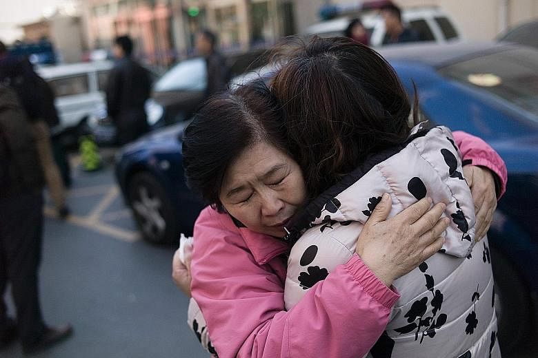 Relatives of Chinese passengers aboard missing Flight MH370 comforting each other yesterday outside the Beijing Rail Transportation Court, which has been designated to handle MH370 cases. The plane, with 239 people on board, including 153 Chinese cit