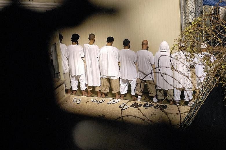 A group of detainees performing their morning prayers in Camp Delta, Guantanamo Bay Naval Base, in this photo taken in 2009. The problem for each detainee is that the US government has to find a place that is willing to take him, and that can be trus
