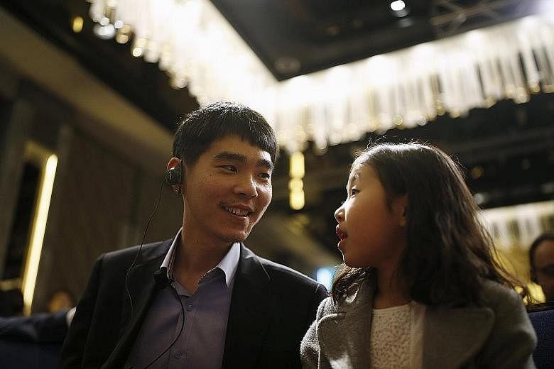 Nine-dan player Lee Se Dol, 32, with his daughter during a news conference in Seoul, South Korea, yesterday.