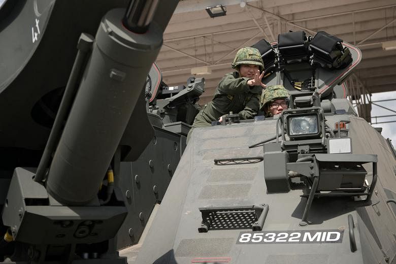 Third Warrant Officer Lee Jia Yan (far left) coaching Third Sergeant Keno Chan in an armoured engineer vehicle at Sungei Gedong Camp. When the 32-year-old 3WO Lee enlisted almost 10 years ago, there were only two other women on basic military training. In