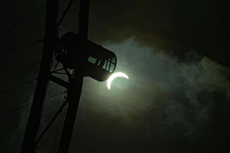 The Sun seen as a crescent at 8.29am yesterday, with a capsule of the Singapore Flyer in the foreground. In Singapore, the solar eclipse started at about 7.20am and peaked just past 8.20am.