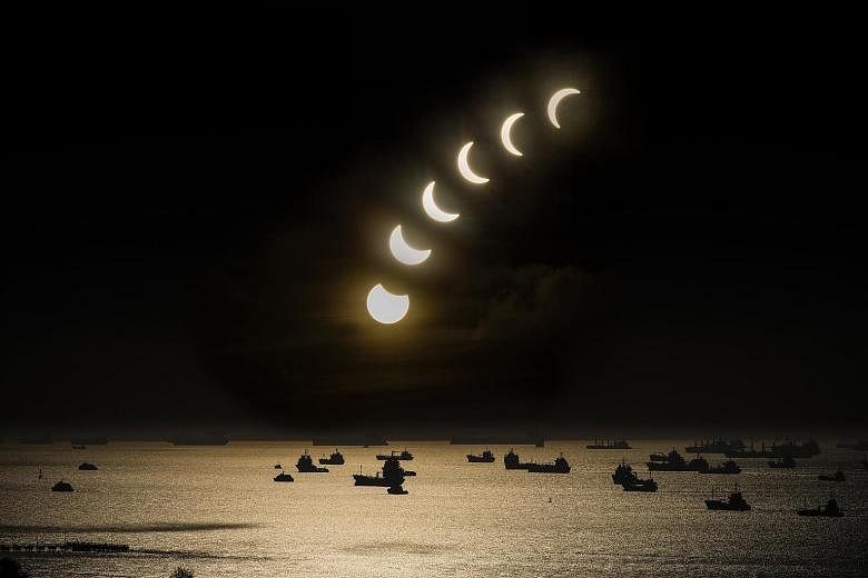 Left: In Thailand, students held up handmade shields during the eclipse in Phuket yesterday. Above: A composite image of seven photographs capturing the partial eclipse in East Coast, shot from the 20th storey of Neptune Court between 7.30am and 8.23