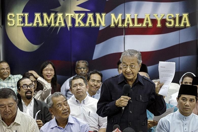 Dr Mahathir (standing) reading the declaration against Malaysian Prime Minister Najib Razak during a media conference in Kuala Lumpur last Friday.