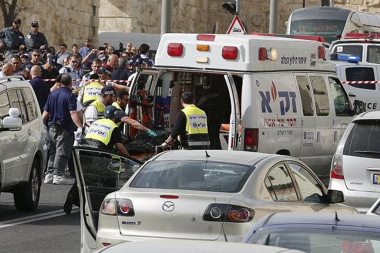 Israeli emergency personnel evacuating the body of one of the two Palestinian assailants whom police said carried out a drive-by shooting on a commuter bus in an east Jerusalem suburb yesterday. The duo were shot dead by police just outside Jerusalem