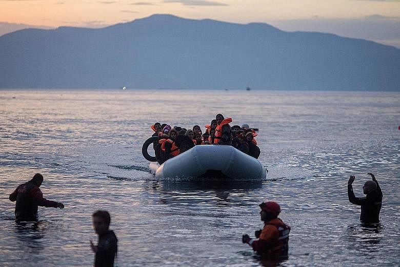 Refugees on a rubber boat arriving on the Greek island of Lesbos yesterday. Dr Merkel's deal to stop refugees from washing up on Europe's shores could well be torn apart by other European leaders even before it has any chance of being implemented.