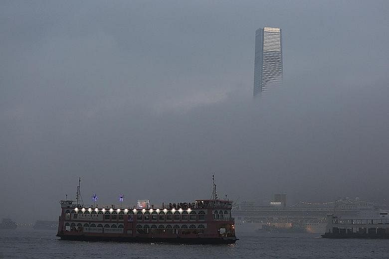 The 484m International Commerce Centre - the highest skyscraper in Hong Kong - vanishing as heavy fog cloaked Victoria Harbour yesterday. According to the Hong Kong Observatory, an intense north-east monsoon is bringing cold weather to the coastal ar