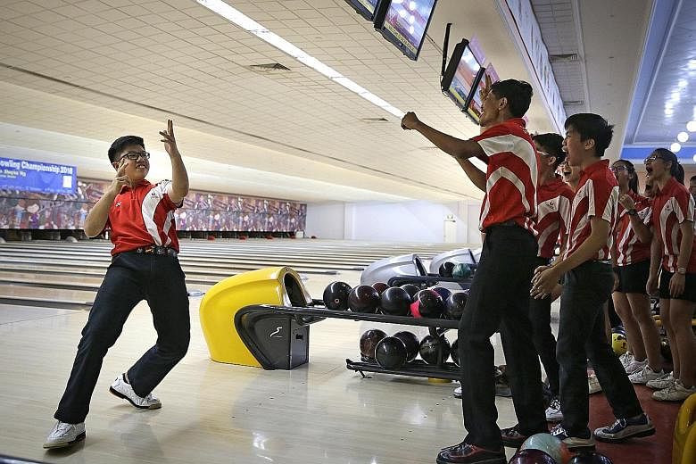 Singapore Sports School's Jarred Lim celebrates a strike with his team-mates and coach. His team clinched the bowling B Division boys' doubles and quartet events while the girls team swept the singles, doubles, quartet and all events titles to finish