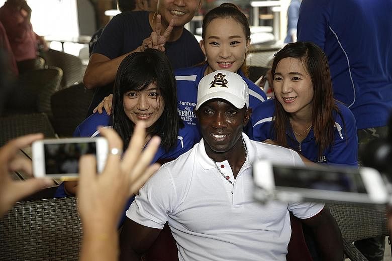 Former Man United striker Dwight Yorke posing for photos with staff of The Chamber at a meet-and-greet session yesterday. The Champions League winner is open to the idea of managing an S-League team.