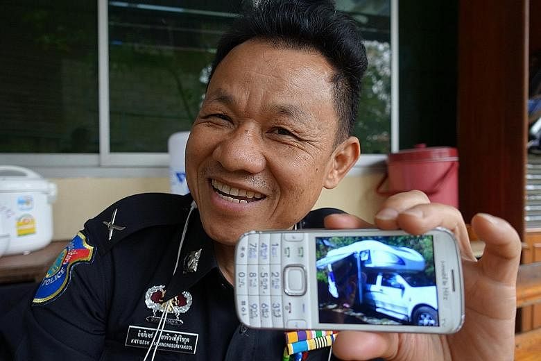 Thai tourist policeman Kitidesh Tajiwongsuriyakool with a photo of a campervan that was driven by a young Chinese couple travelling with their child through Chiang Mai last month. The senior sergeant-major made friends with the couple and chatted, di