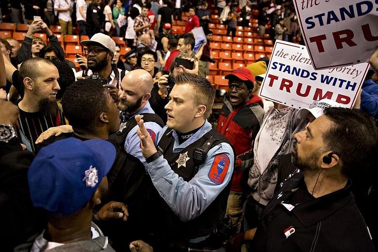 A police officer trying to calm a rally attendee after the cancellation of a Trump campaign event at the University of Illinois at Chicago on Friday.
