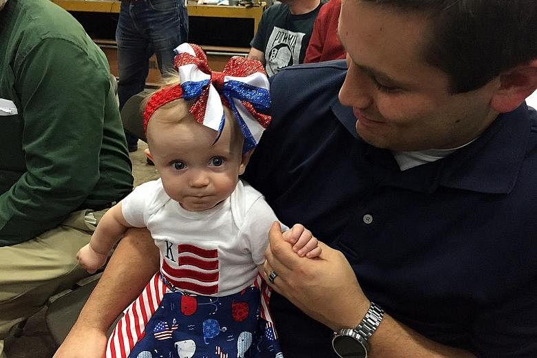Supporters attending Democratic presidential hopeful Mrs Clinton's rally on Saturday in Youngstown, Ohio. Unlike Mr Trump, she and Mr Bernie Sanders played to smaller, more respectful crowds. Nine-month-old toddler Kinsley's parents dressed her up in
