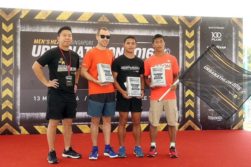 Winner of the event Jason Lawrence, 35, with (left) Kelvin Tan (editor of Men's Health), runner-up (second from right) Jite, 20, and third-place finisher (right) Kumar Sunuwar, 24. Participants had to climb over barriers and show nifty ropework at th