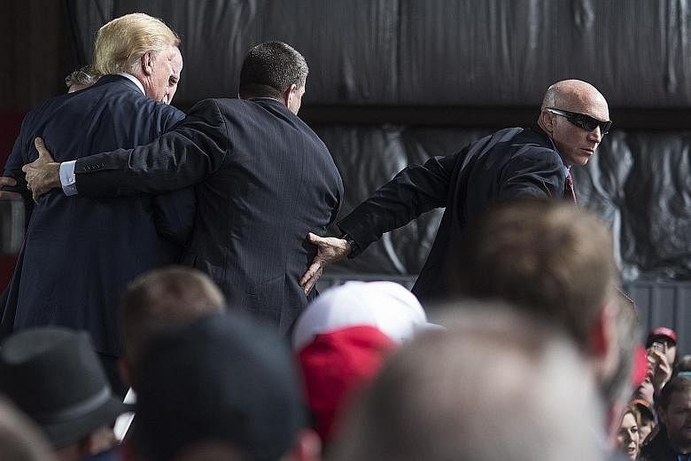 US Secret Service agents surrounding Mr Trump after a disturbance during a campaign rally in Vandalia, Ohio, on Saturday.