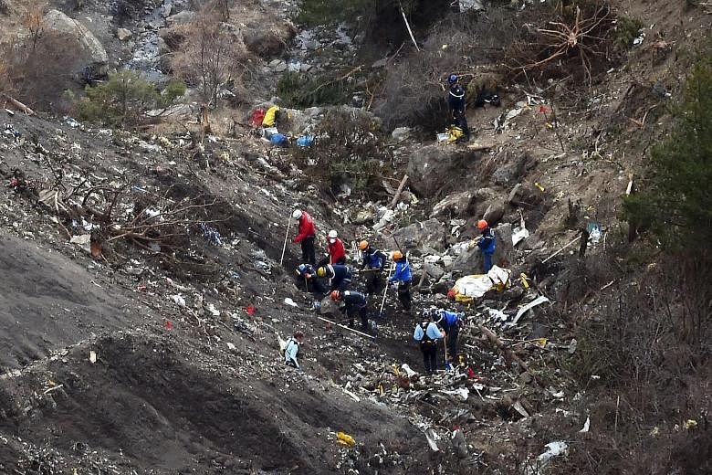French authorities at the site (above) where the Germanwings jet crashed in the French Alps last year. The French aviation investigation agency BEA says co-pilot Andreas Lubitz (below) had begun to show symptoms that could be consistent with a psycho