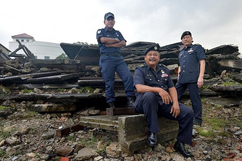 (From left) Senior Warrant Officers Isnin Ghani, Mohd Salleh Ali and Jimmy Tan at the Civil Defence Academy's field training area, where "ruins" made of concrete slabs and debris simulate a collapsed structure. They dug a tunnel with their hands and 