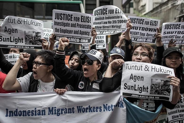 Protesters shouting slogans for migrant workers' rights outside an employment agency in Hong Kong last year. One in three households with children in Hong Kong employs a foreign domestic worker, who works an average of over 70 hours a week.