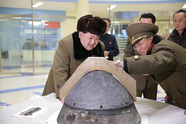 North Korean leader Kim being shown part of a locally-made missile warhead in an undated picture released by the country's official news agency yesterday. The North has issued belligerent statements almost daily since new UN sanctions kicked in this 