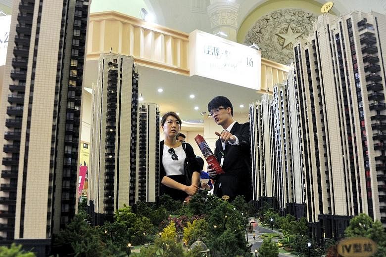 A sales agent (right) and a potential client at a real estate exhibition in Shanghai last April. The diverging property price trend between the top- and lower-tier cities poses a problem for China's housing market policies.