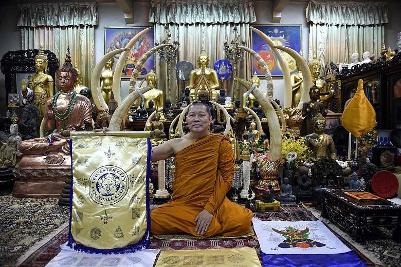 Thai monk Phra Prommangkalachan, holding a banner with Leicester City's crest in his temple in Bangkok, has been making regular visits to the Foxes' King Power Stadium to give his blessings to the players.