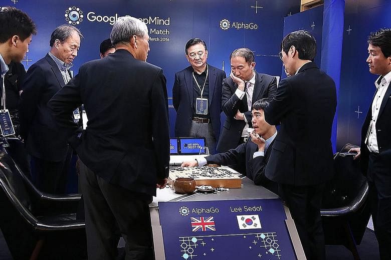 South Korean Go master Lee Se Dol (seated), one of the greatest modern players of the ancient board game, reviewing the game after he lost the fifth and final round against the supercomputer AlphaGo created by Google company DeepMind, in Seoul yester