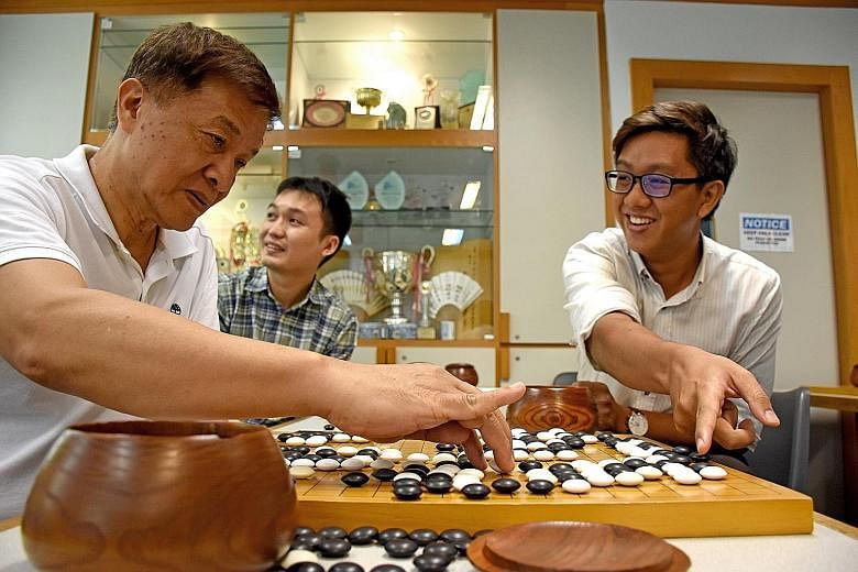 (From far left) SWA head coach Yang Jin Hua, 64, and Weiqi enthusiasts Ho Jia Xuan, 29, and Kenneth Ng, 30, enjoying a game of Weiqi, or Go, as they watched a live streaming of the game between Mr Lee Se Dol and supercomputer AlphaGo.