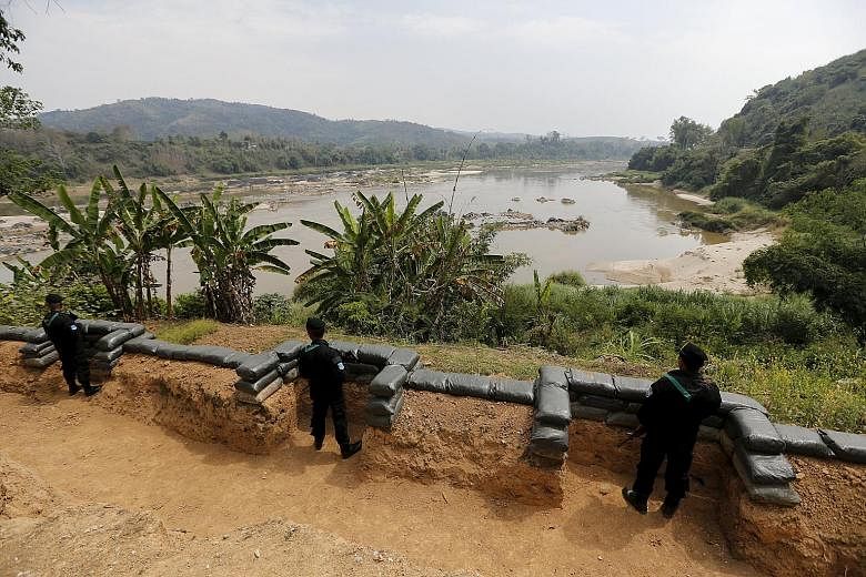Thai soldiers standing guard at a Mekong river base on the border between Thailand and Laos. Patrols on the river by the Laotian army and Myanmar police have subdued pirates who once robbed cargo ships with impunity. But drug production and trafficki