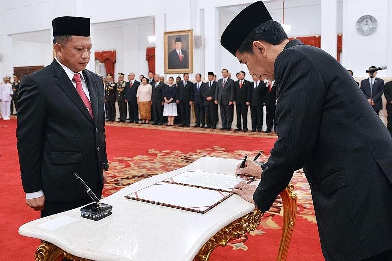 President Joko signing the documents during the swearing-in ceremony of General Tito as the new chief of the national counter-terrorism agency yesterday at the presidential palace in Jakarta.